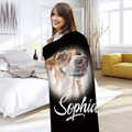 A woman is standing in a room with a black blanket featuring a dog's face and the name 