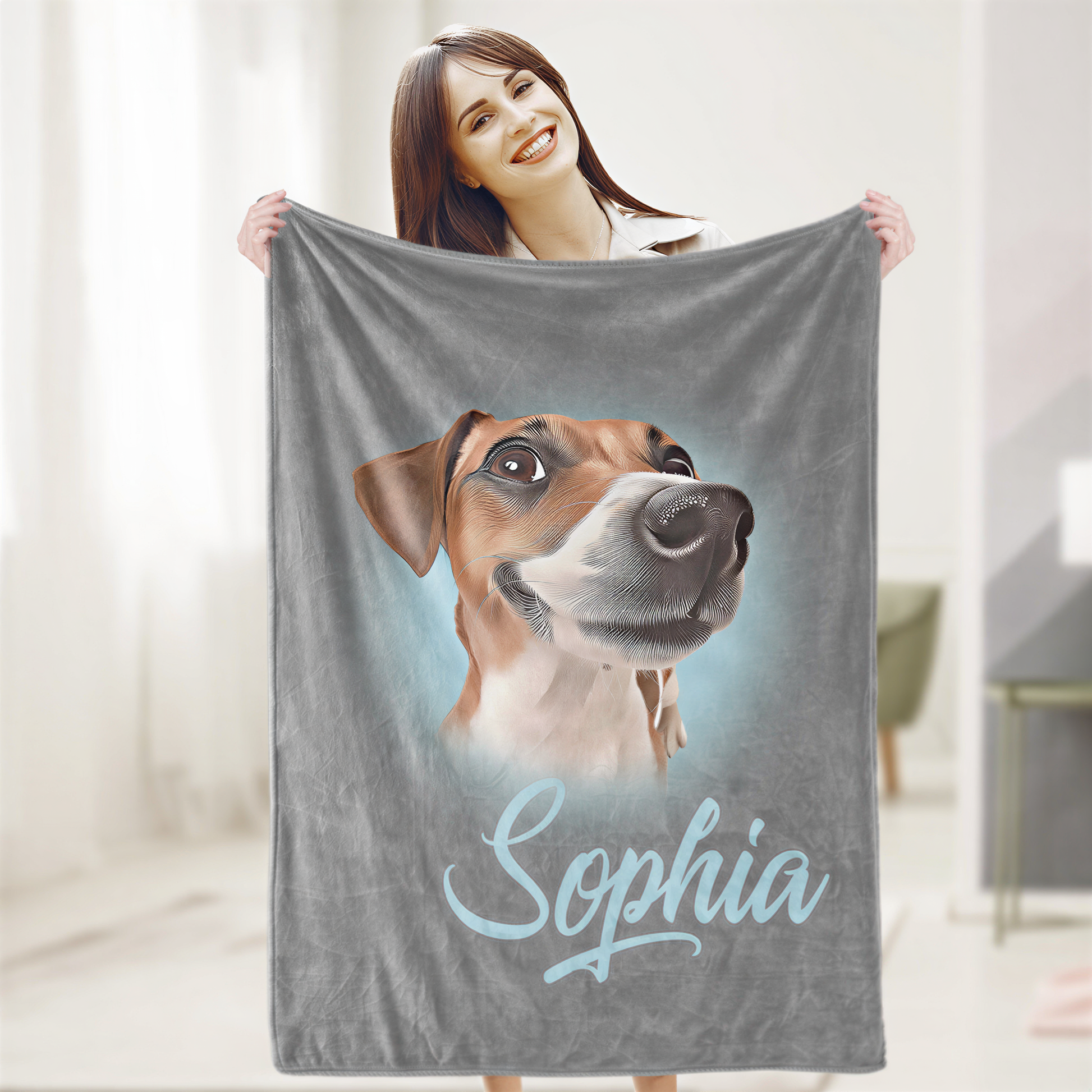 A woman is holding up a gray blanket with a picture of a dog on it, and the name "Sophia" written below the image.