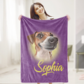 A woman is holding a purple blanket with a dog's face printed on it, and the name 