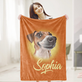 A woman is holding up an orange blanket with a picture of a dog on it, and the name 