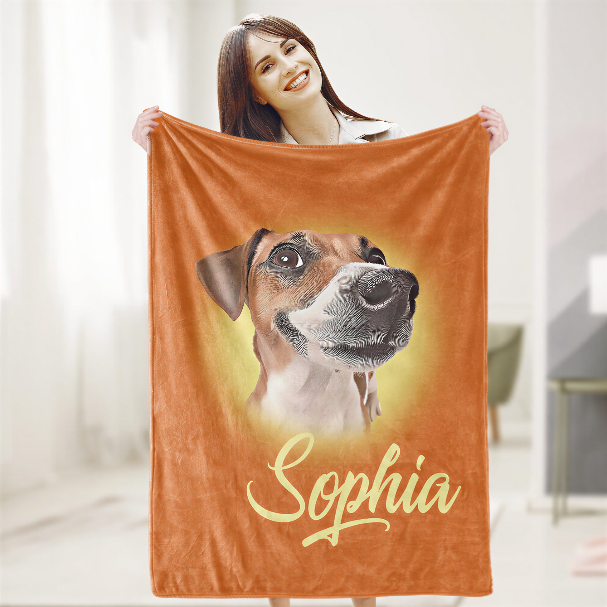 A woman is holding up an orange blanket with a picture of a dog on it, and the name "Sophia" written below the image.